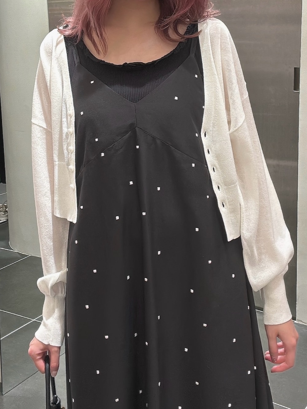 ブラック系のワンピース、ホワイト系のカーディガン/ボレロ、ブラック系のタンクトップを着用したレディースの夏コーディネートの6枚目の写真