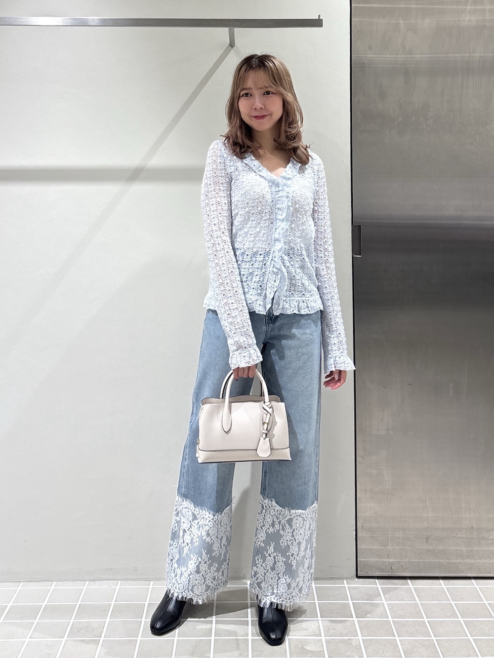 ホワイト系のカーディガン/ボレロ、ブルー系のデニムパンツ、ブラック系のブーツを着用したレディースの夏コーディネートの4枚目の写真