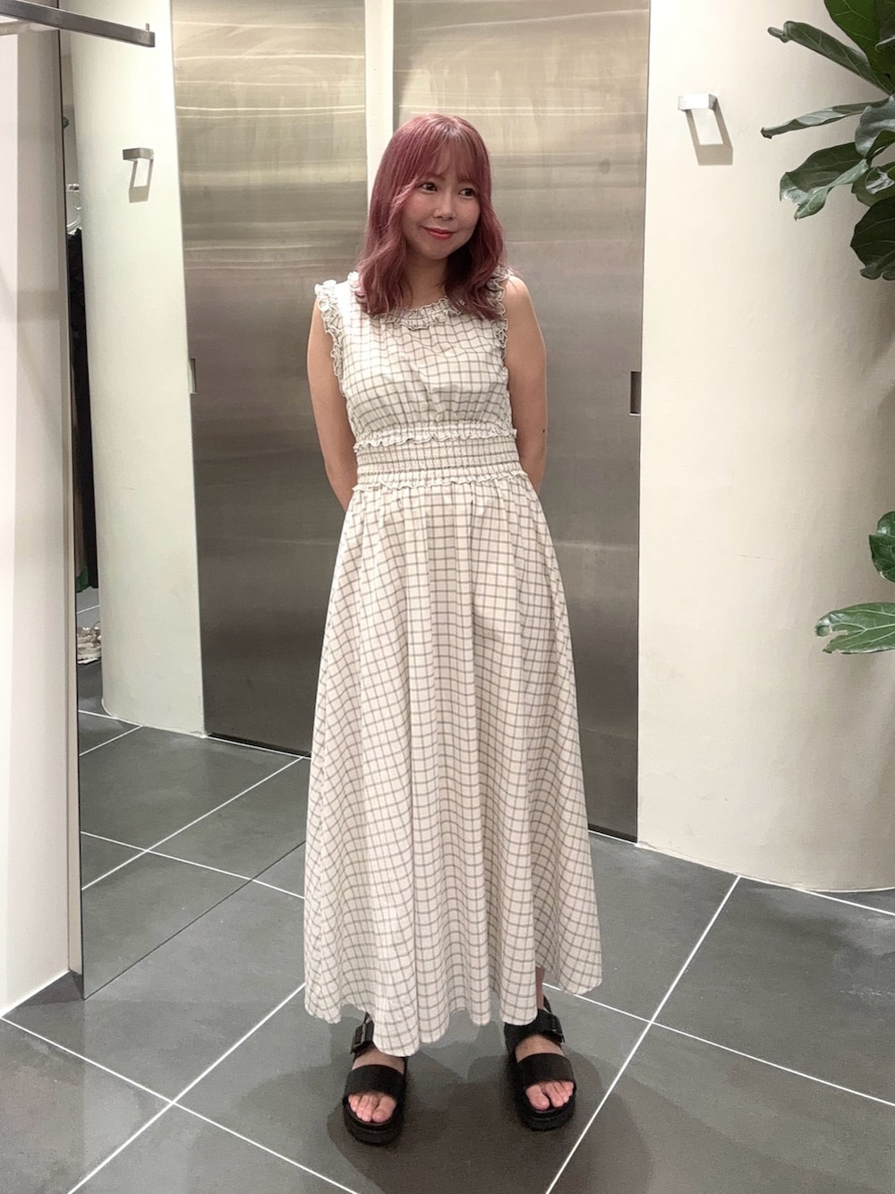 ホワイト系のワンピース、ブラック系のサンダルを着用したレディースの夏コーディネートの2枚目の写真