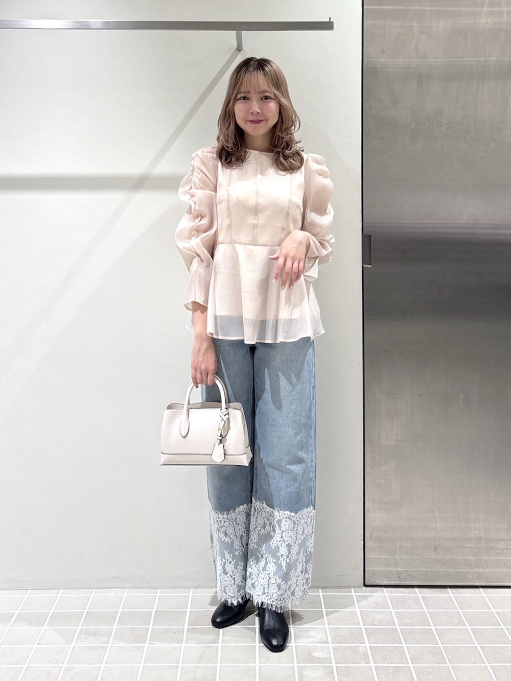 ベージュ系のシャツ/ブラウス、ブルー系のデニムパンツ、ホワイト系のトートバッグを着用したレディースの夏コーディネートの4枚目の写真