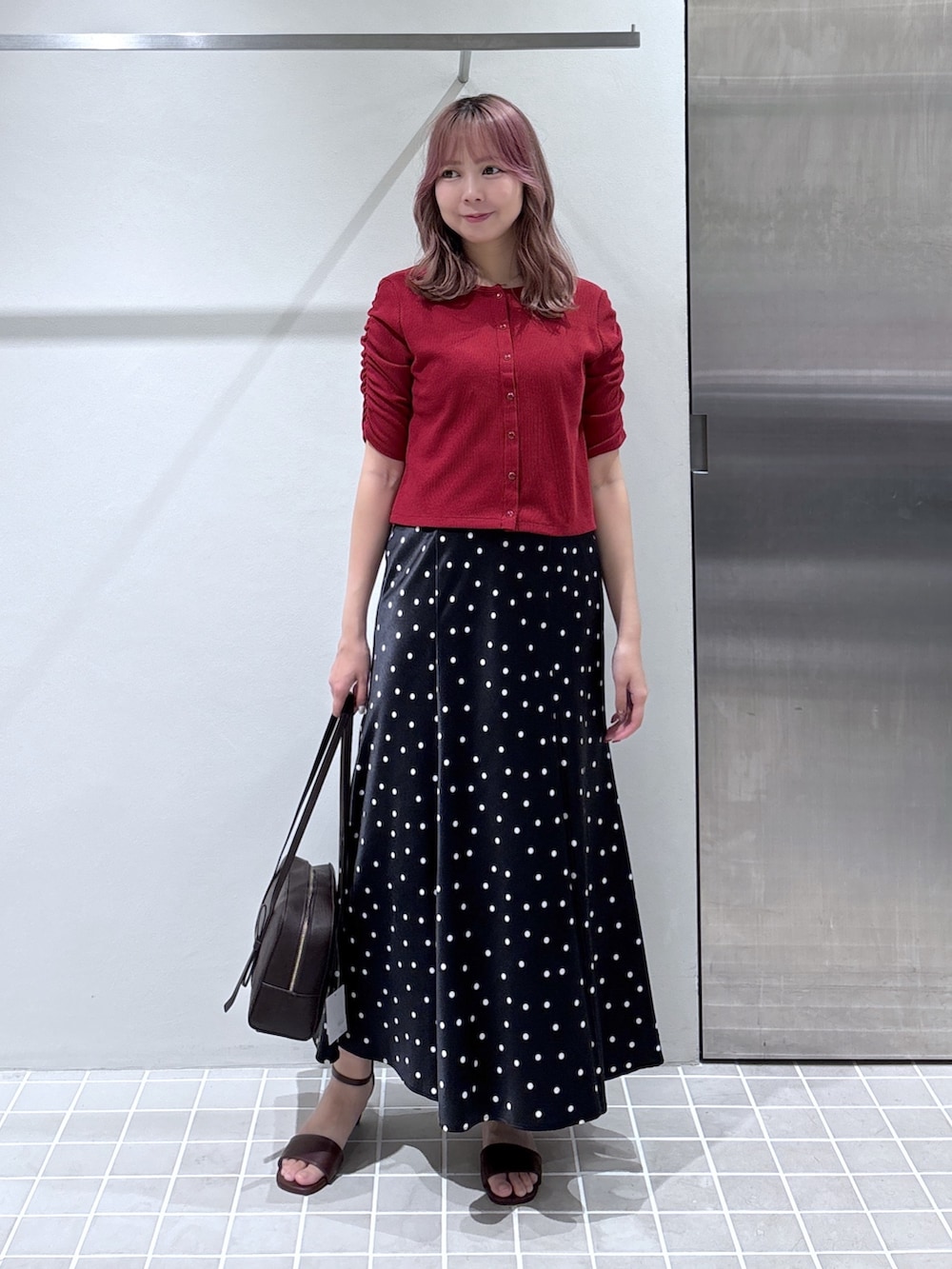 レッド系のTシャツ/カットソー、ブラック系のスカート、ブラウン系のボストンバッグを着用したレディースの夏コーディネートの4枚目の写真