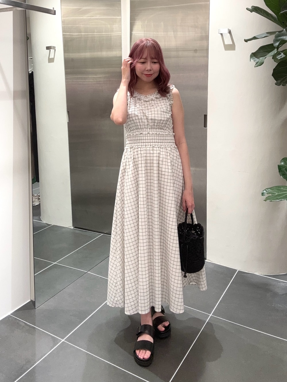 ホワイト系のワンピース、ブラック系のサンダルを着用したレディースの夏コーディネートの4枚目の写真