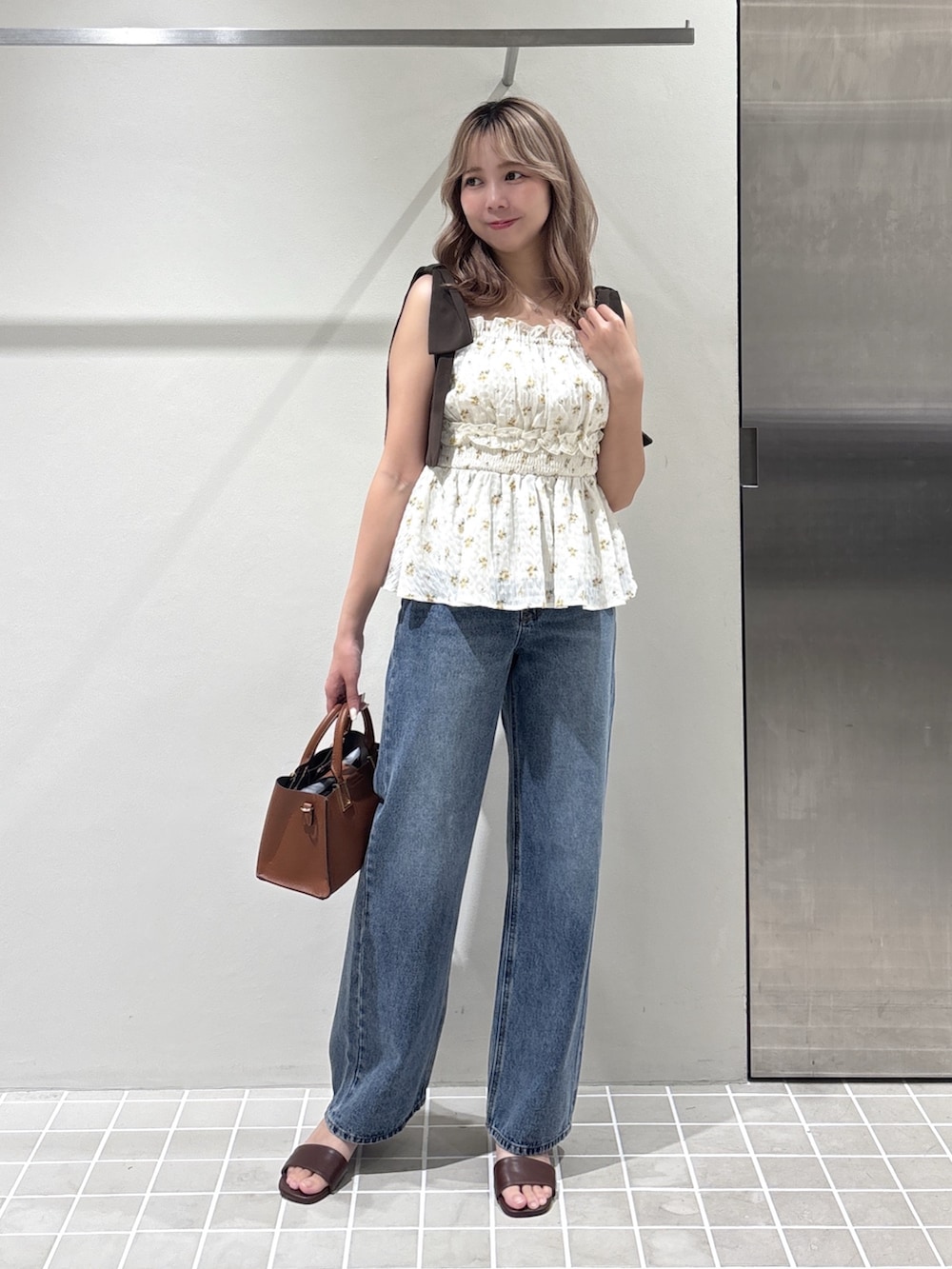 ベージュ系のシャツ/ブラウス、ブルー系のデニムパンツ、イエロー系のトートバッグを着用したレディースの夏コーディネートの2枚目の写真