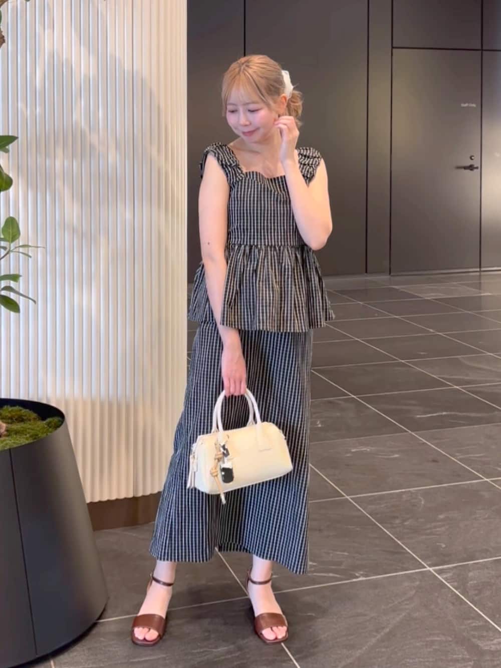 ブラック系のシャツ/ブラウス、ブラック系のワンピース、ホワイト系のボストンバッグを着用したレディースの夏コーディネートの6枚目の写真
