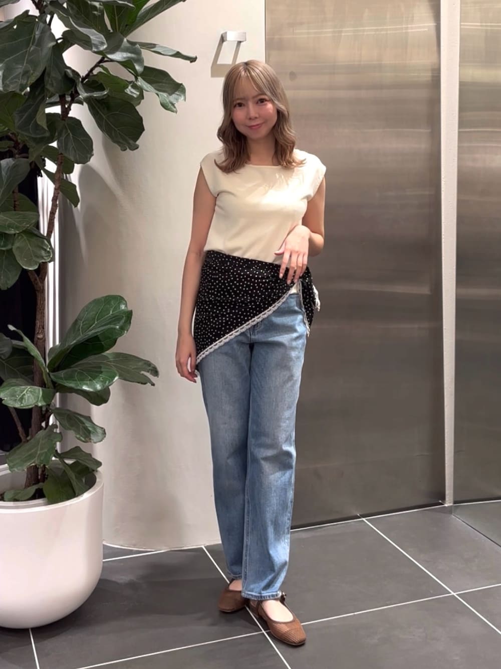 ホワイト系のニット/セーター、ブルー系のデニムパンツ、ブラウン系のサンダルを着用したレディースの夏コーディネートの2枚目の写真