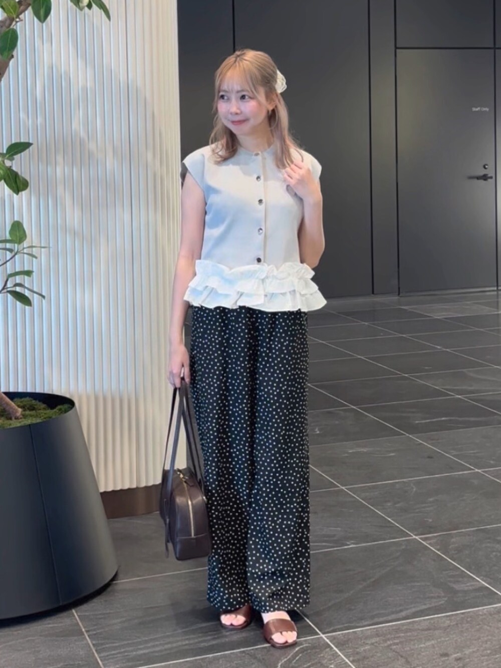 グレー系のベスト、ブラック系のその他パンツ、ブラウン系のサンダルを着用したレディースの夏コーディネートの4枚目の写真