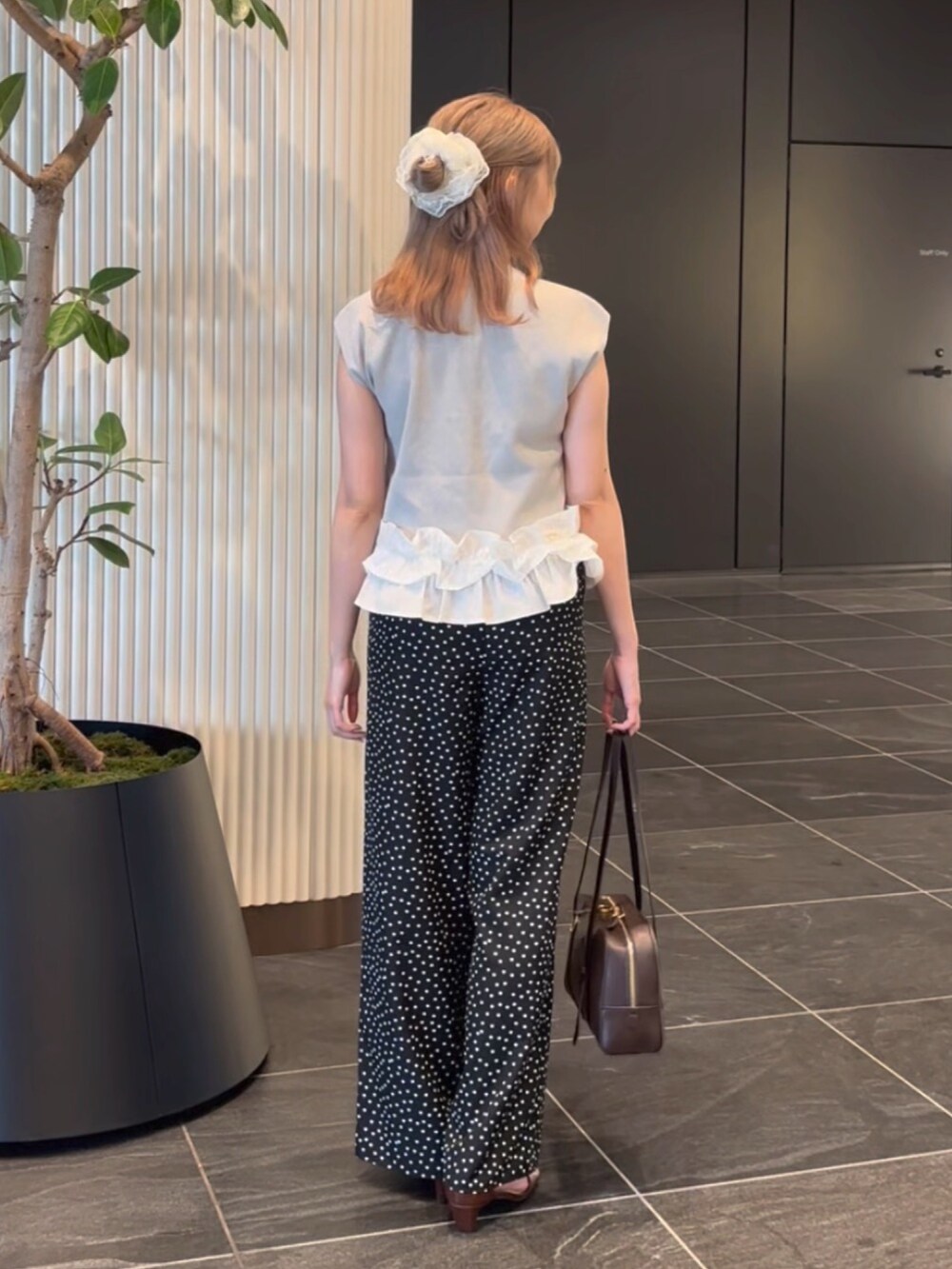 グレー系のベスト、ブラック系のその他パンツ、ブラウン系のサンダルを着用したレディースの夏コーディネートの7枚目の写真