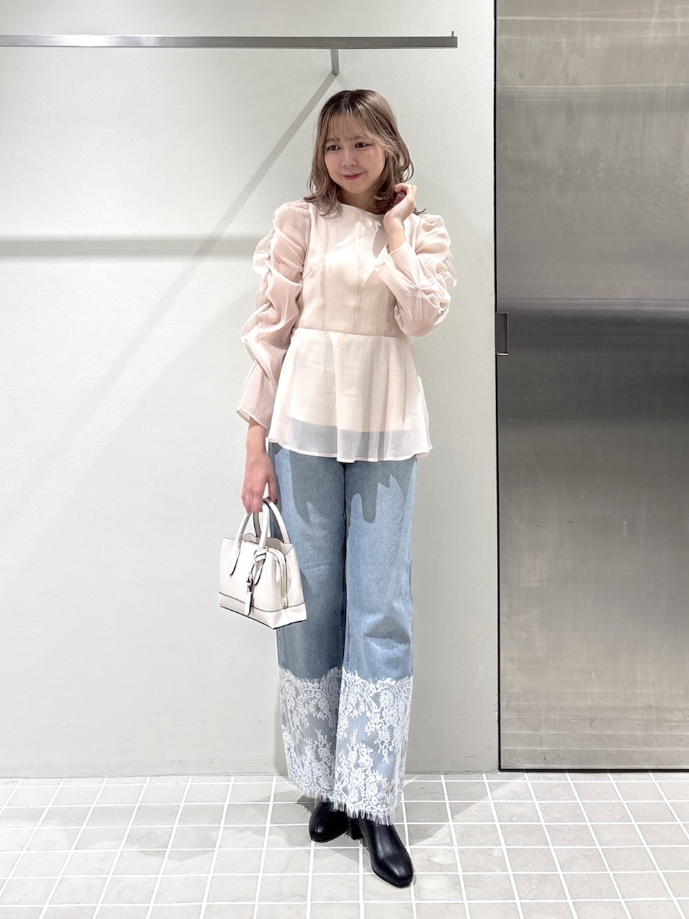 ベージュ系のシャツ/ブラウス、ブルー系のデニムパンツ、ホワイト系のトートバッグを着用したレディースの夏コーディネートの3枚目の写真