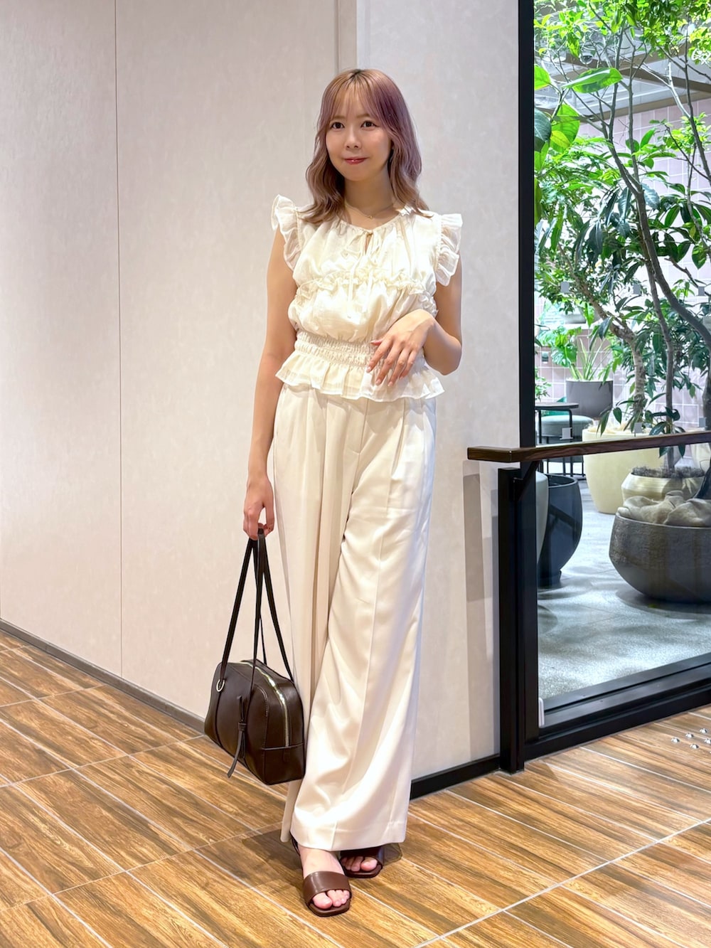 ホワイト系のシャツ/ブラウス、ホワイト系のその他パンツ、ブラウン系のボストンバッグを着用したレディースの夏コーディネートの3枚目の写真