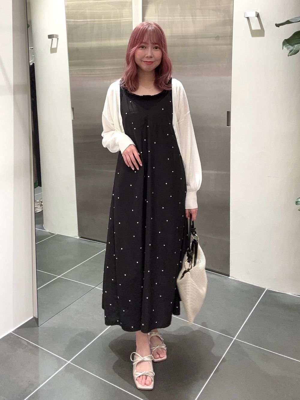 ブラック系のワンピース、ホワイト系のカーディガン/ボレロ、ブラック系のタンクトップを着用したレディースの夏コーディネートの2枚目の写真