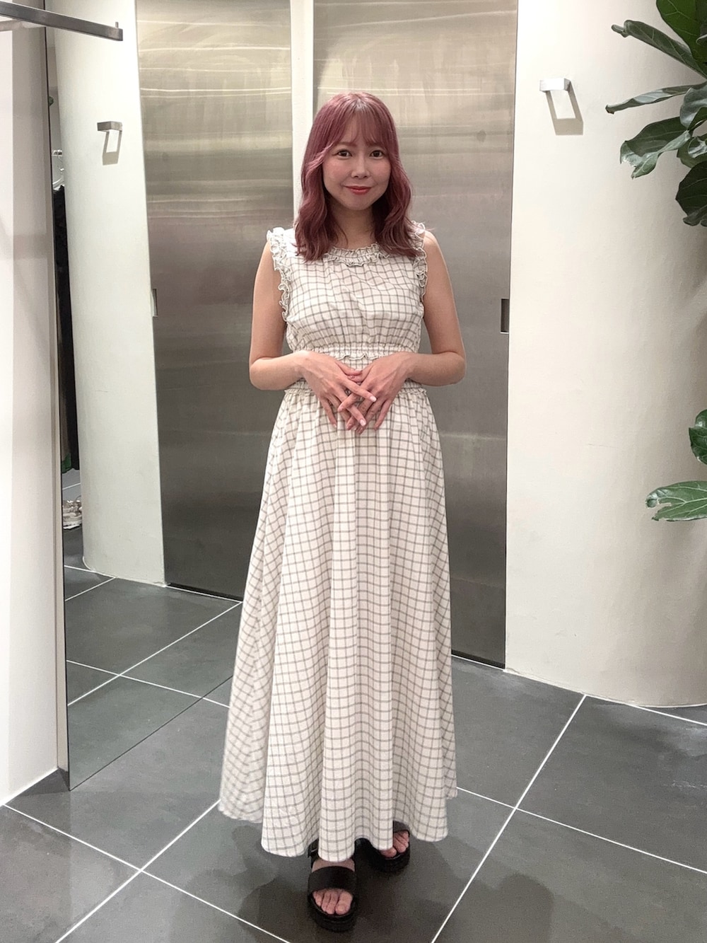 ホワイト系のワンピース、ブラック系のサンダルを着用したレディースの夏コーディネートの3枚目の写真