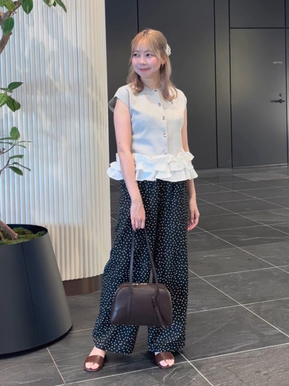 グレー系のベスト、ブラック系のその他パンツ、ブラウン系のサンダルを着用したレディースの夏コーディネートの2枚目の写真