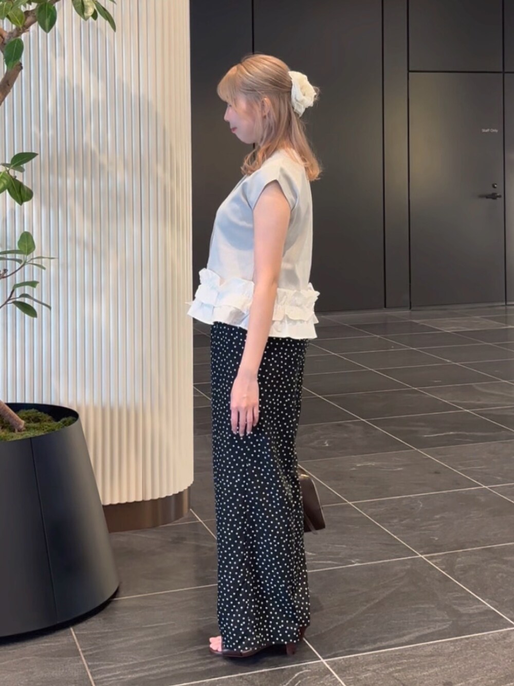 グレー系のベスト、ブラック系のその他パンツ、ブラウン系のサンダルを着用したレディースの夏コーディネートの6枚目の写真