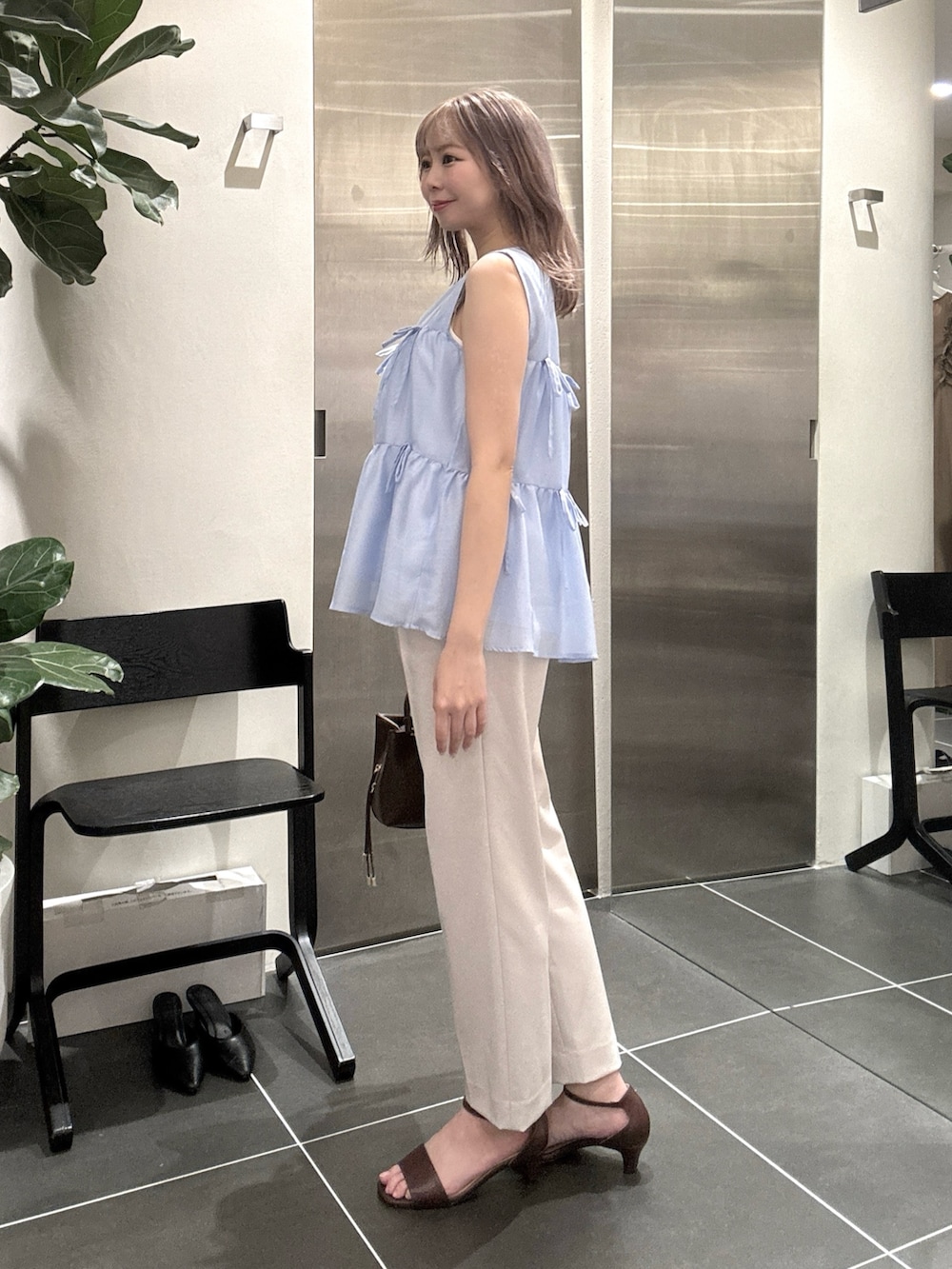 ブルー系のシャツ/ブラウス、ブラック系のサンダル、ブラウン系のボストンバッグを着用したレディースの夏コーディネートの5枚目の写真