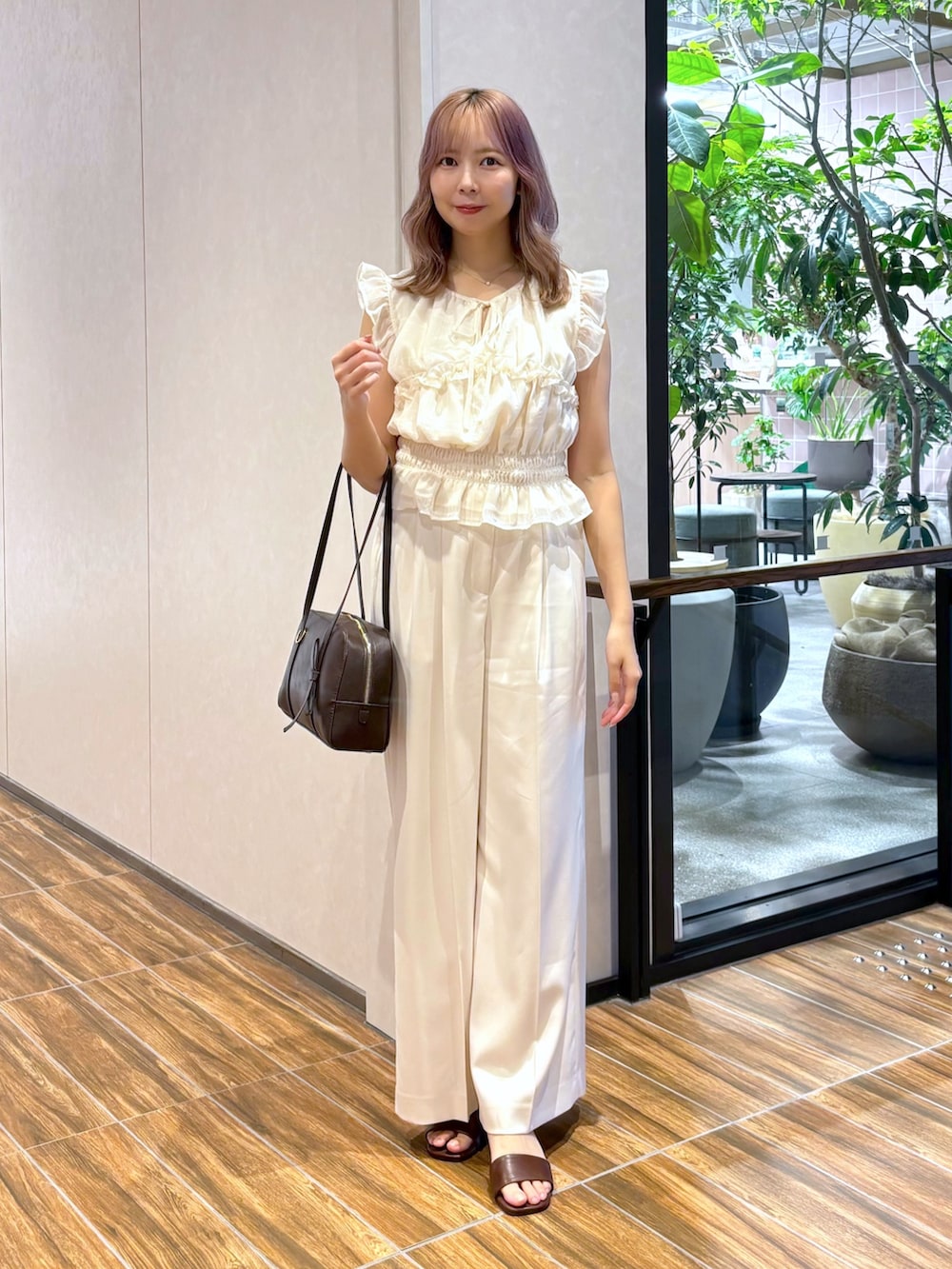 ホワイト系のシャツ/ブラウス、ホワイト系のその他パンツ、ブラウン系のボストンバッグを着用したレディースの夏コーディネートの4枚目の写真