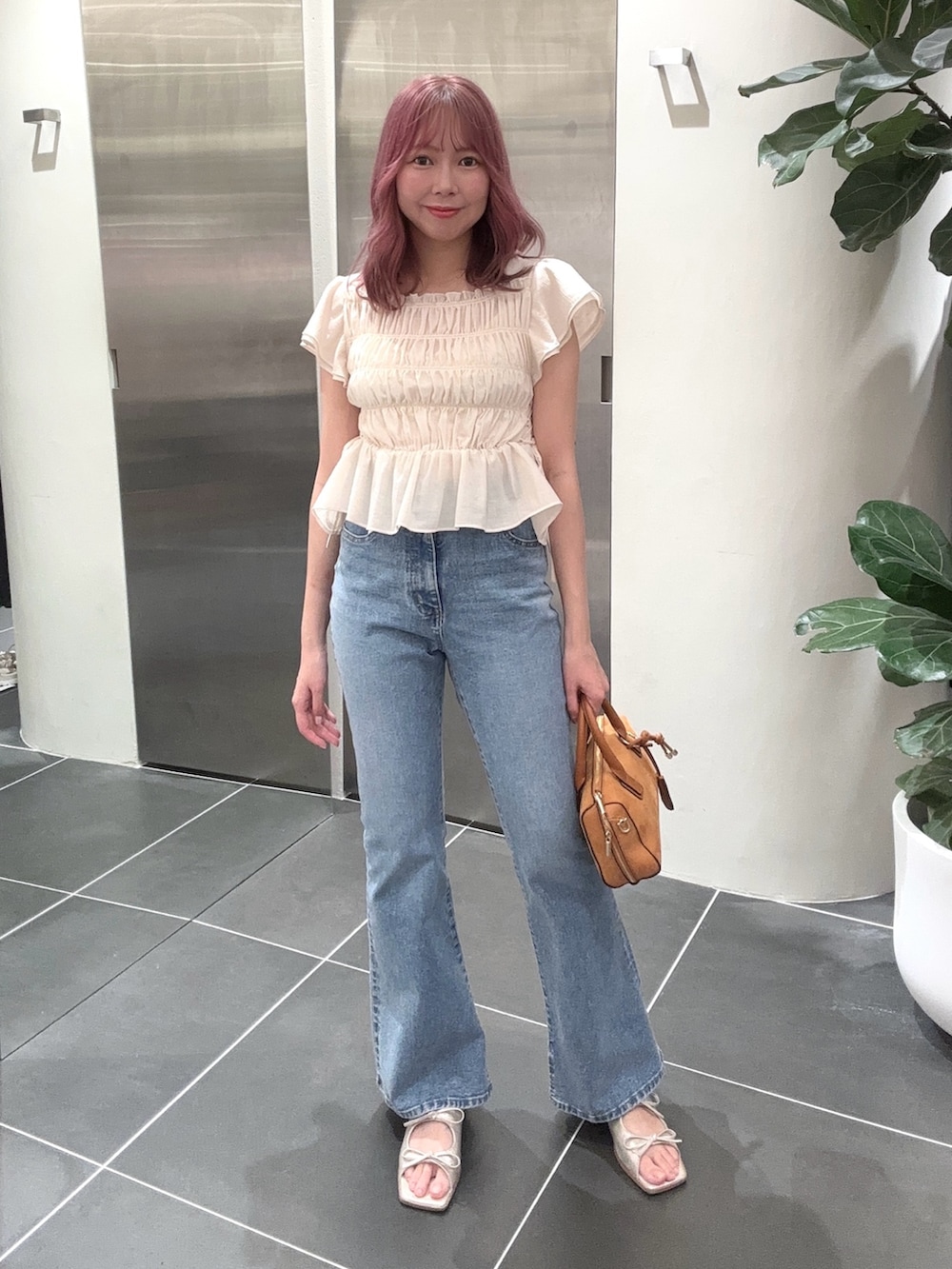 ブルー系のデニムパンツ、オレンジ系のボストンバッグ、ホワイト系のシャツ/ブラウスを着用したレディースの夏コーディネートの3枚目の写真
