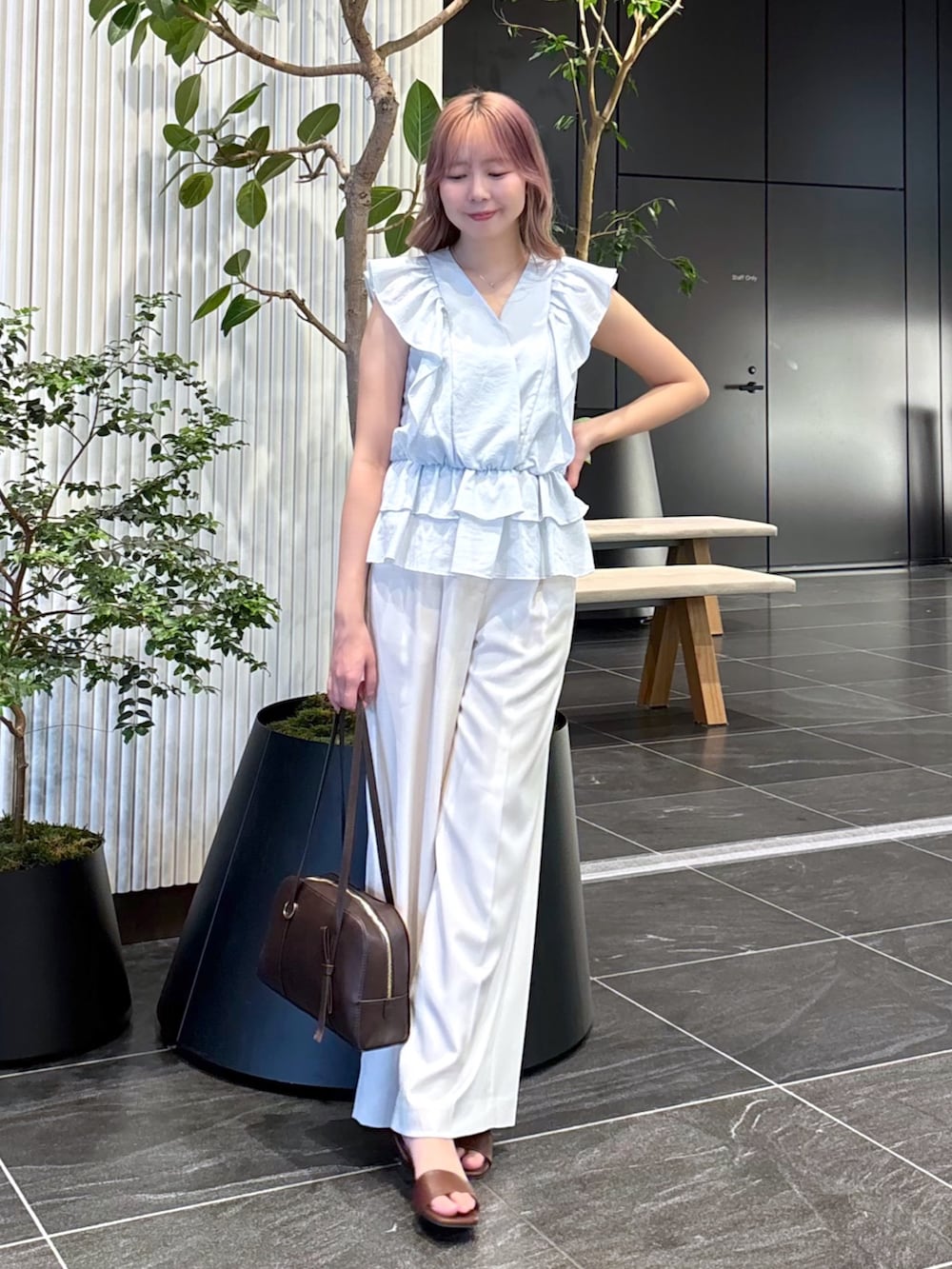 ブルー系のシャツ/ブラウス、ホワイト系のその他パンツ、ブラウン系のボストンバッグを着用したレディースの夏コーディネートの2枚目の写真