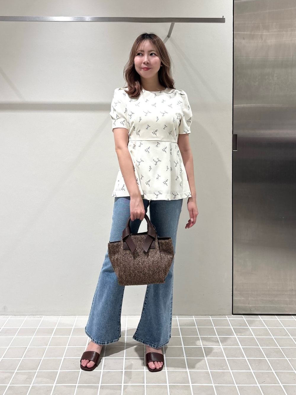 ホワイト系のシャツ/ブラウス、ブルー系のデニムパンツ、ブラウン系のトートバッグを着用したレディースの夏コーディネートの3枚目の写真