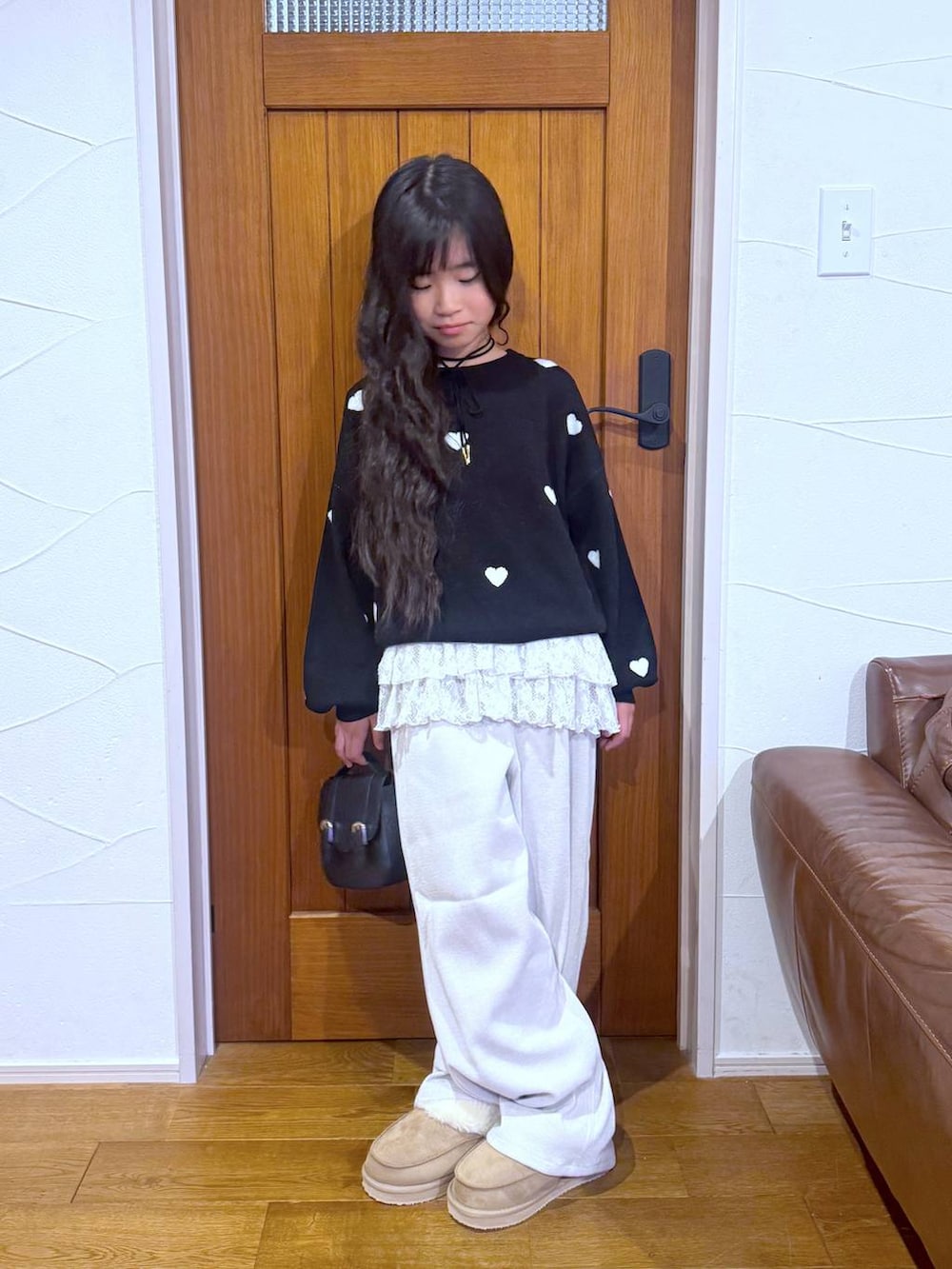 ブラック系のカーディガン/ボレロ、ホワイト系のスウェット、ベージュ系のその他パンツを着用したキッズの冬コーディネートの7枚目の写真