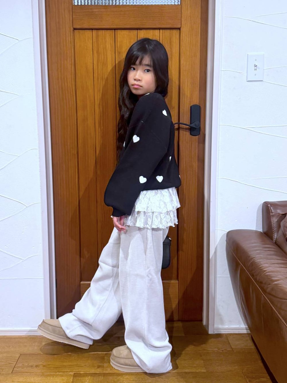 ブラック系のカーディガン/ボレロ、ホワイト系のスウェット、ベージュ系のその他パンツを着用したキッズの冬コーディネートの2枚目の写真