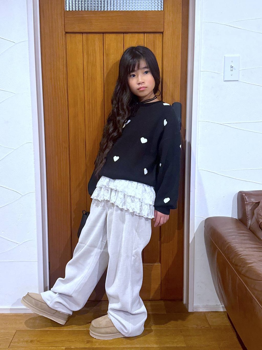 ブラック系のカーディガン/ボレロ、ホワイト系のスウェット、ベージュ系のその他パンツを着用したキッズの冬コーディネートの8枚目の写真