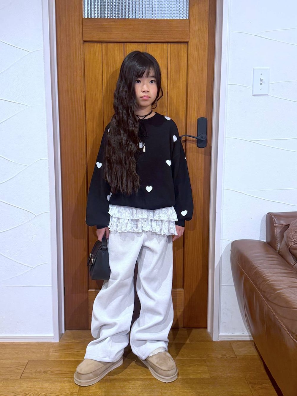 ブラック系のカーディガン/ボレロ、ホワイト系のスウェット、ベージュ系のその他パンツを着用したキッズの冬コーディネートの5枚目の写真