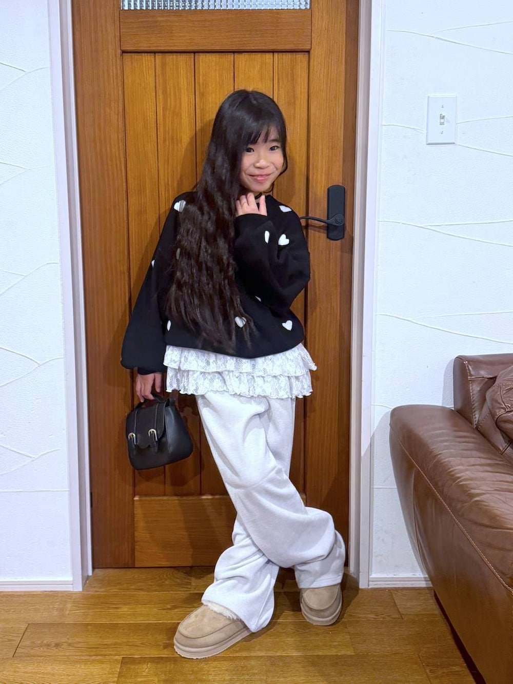 ブラック系のカーディガン/ボレロ、ホワイト系のスウェット、ベージュ系のその他パンツを着用したキッズの冬コーディネートの3枚目の写真