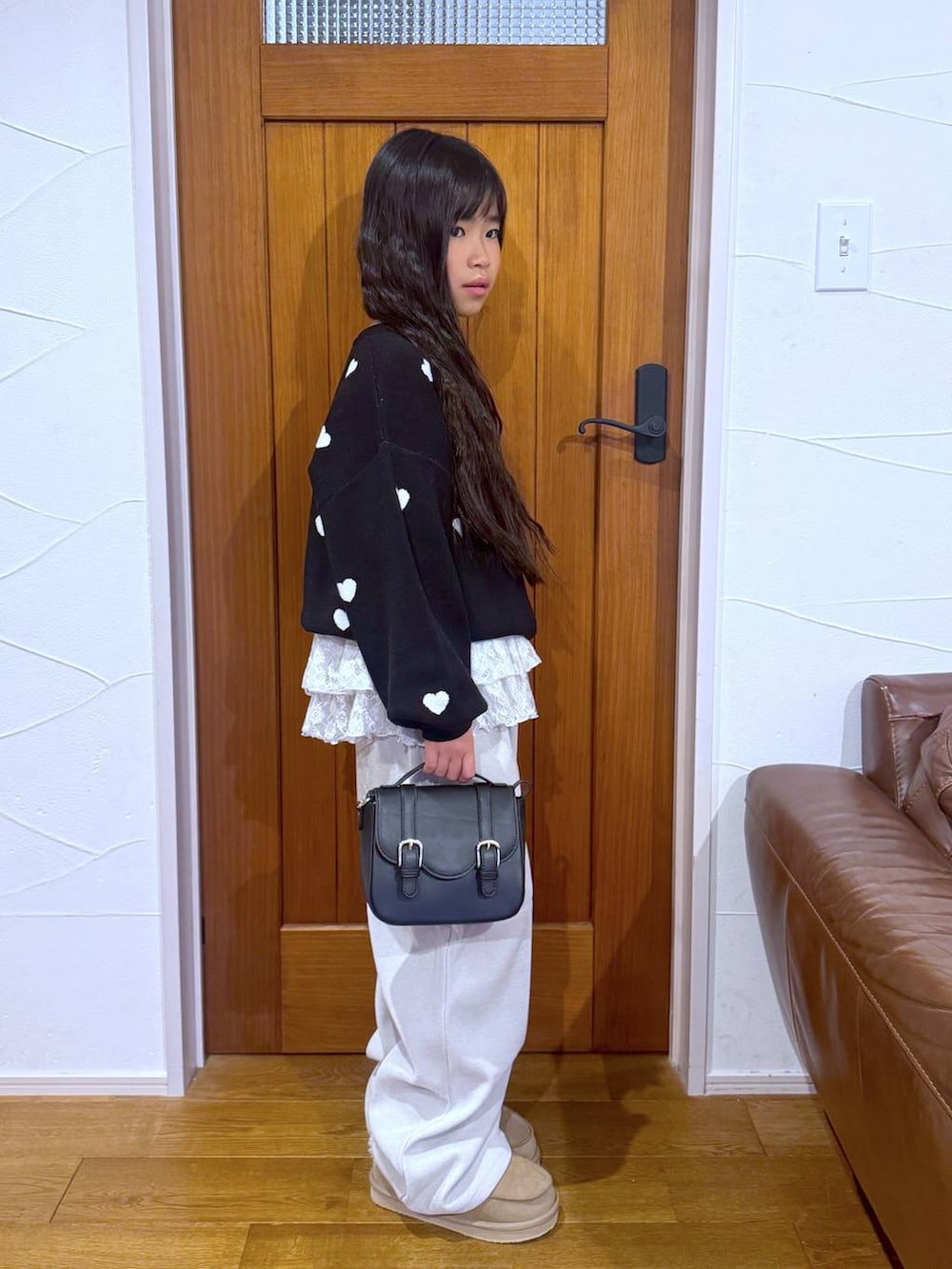 ブラック系のカーディガン/ボレロ、ホワイト系のスウェット、ベージュ系のその他パンツを着用したキッズの冬コーディネートの6枚目の写真