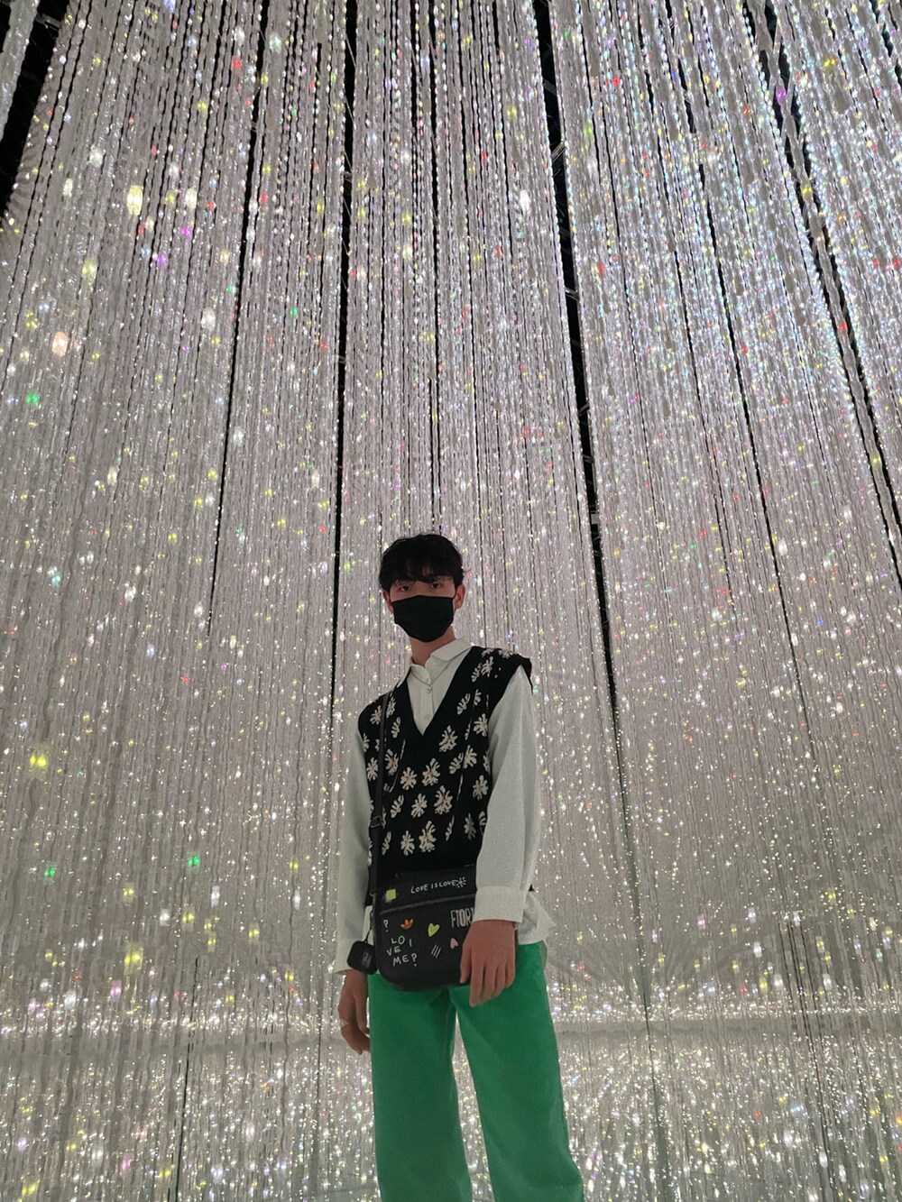 グリーン系のデニムパンツ、ホワイト系のシャツ/ブラウス、ブラック系のニット/セーターを着用したメンズの春コーディネートの2枚目の写真