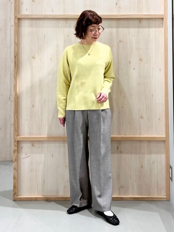 イエロー系のニット/セーター、グレー系のその他パンツ、グレー系のトートバッグを着用したレディースの冬コーディネートの4枚目の写真