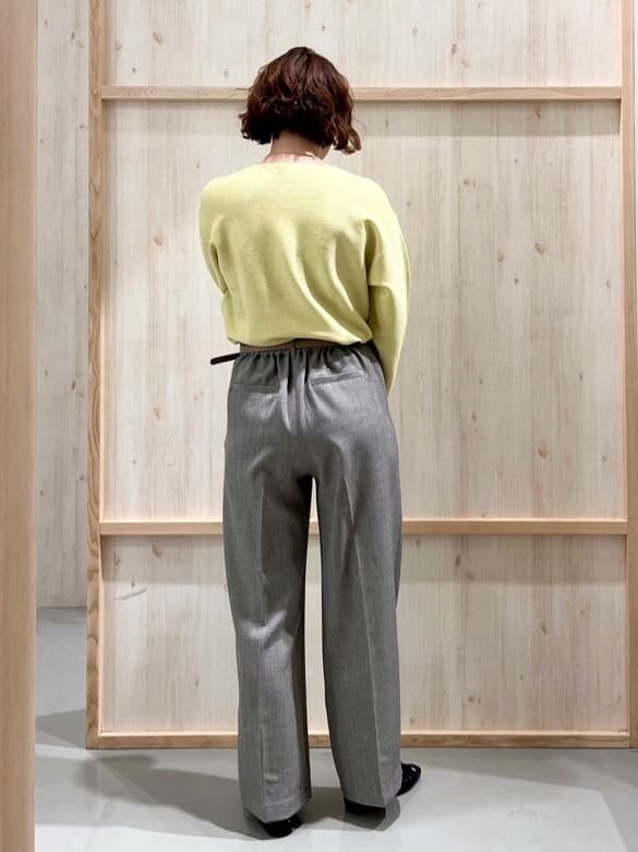 イエロー系のニット/セーター、グレー系のその他パンツ、グレー系のトートバッグを着用したレディースの冬コーディネートの3枚目の写真