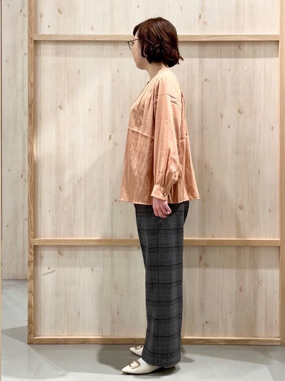 オレンジ系のシャツ/ブラウス、グレー系のその他パンツ、ホワイト系のトートバッグを着用したレディースの冬コーディネートの6枚目の写真