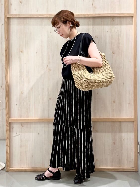 ブラック系のニット/セーター、ブラック系のスカート、ブラック系のトートバッグを着用したレディースの夏コーディネートの4枚目の写真