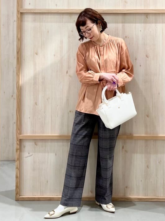 オレンジ系のシャツ/ブラウス、グレー系のその他パンツ、ホワイト系のトートバッグを着用したレディースの冬コーディネートの5枚目の写真