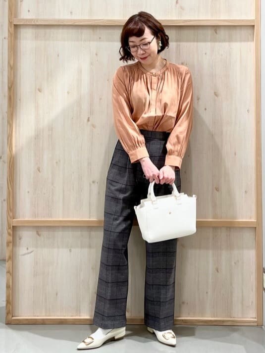 オレンジ系のシャツ/ブラウス、グレー系のその他パンツ、ホワイト系のトートバッグを着用したレディースの冬コーディネートの2枚目の写真