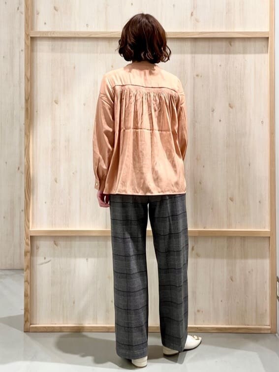 オレンジ系のシャツ/ブラウス、グレー系のその他パンツ、ホワイト系のトートバッグを着用したレディースの冬コーディネートの7枚目の写真
