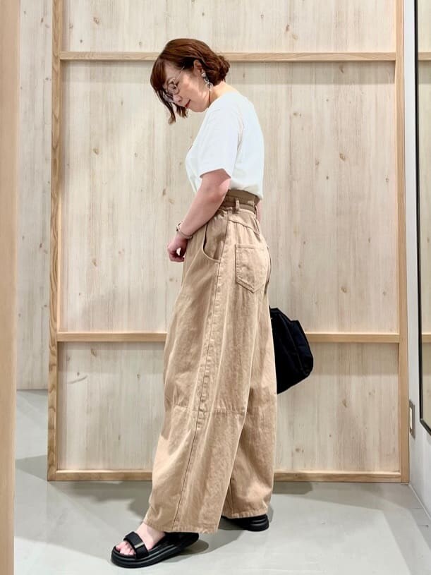 ホワイト系のTシャツ/カットソー、ベージュ系のその他パンツ、ブラック系のハンドバッグを着用したレディースの夏コーディネートの7枚目の写真