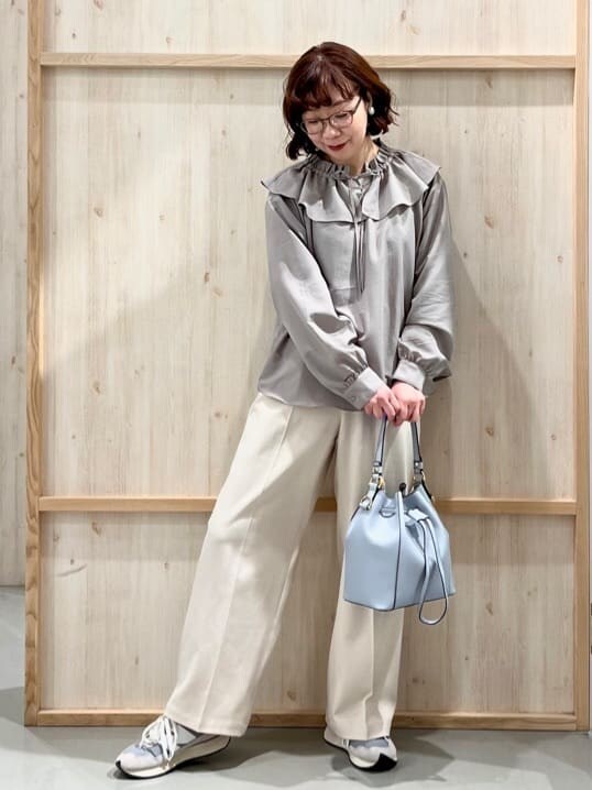 ベージュ系のシャツ/ブラウス、ベージュ系のその他パンツ、ブルー系のショルダーバッグを着用したレディースの春コーディネートの2枚目の写真