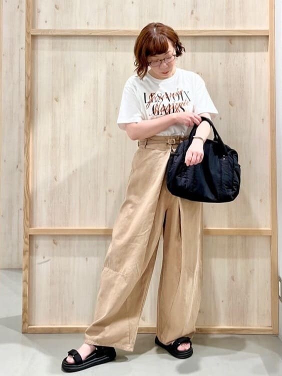 ホワイト系のTシャツ/カットソー、ベージュ系のその他パンツ、ブラック系のハンドバッグを着用したレディースの夏コーディネートの2枚目の写真