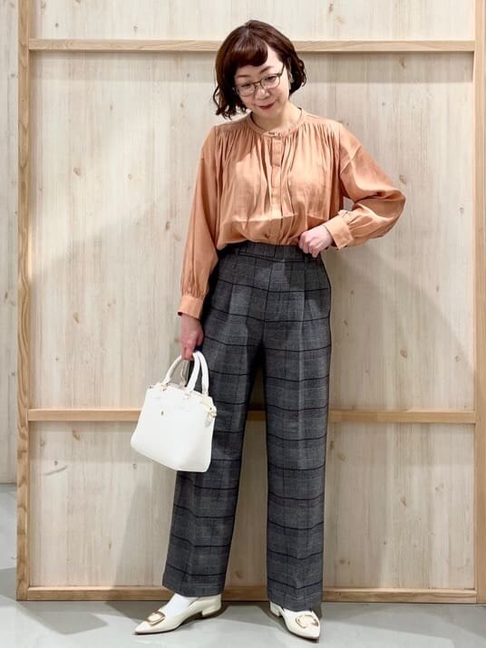 オレンジ系のシャツ/ブラウス、グレー系のその他パンツ、ホワイト系のトートバッグを着用したレディースの冬コーディネートの3枚目の写真