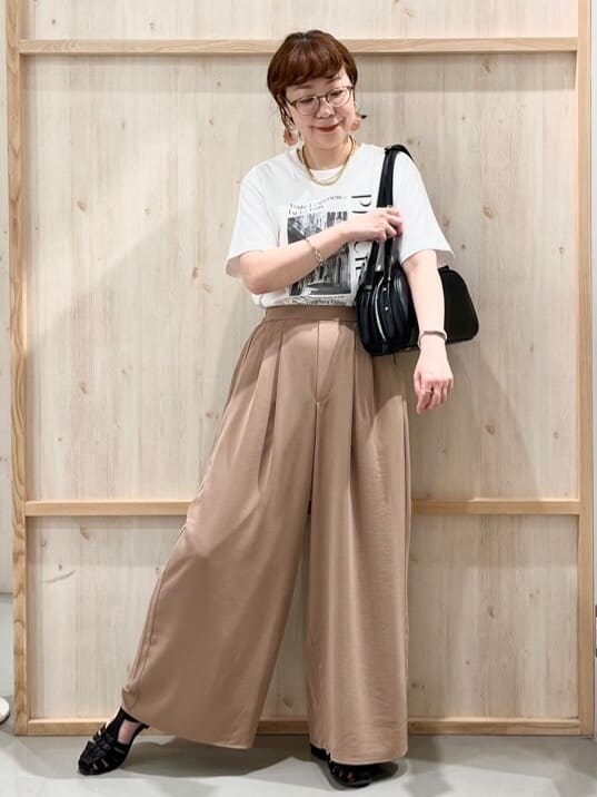 ホワイト系のTシャツ/カットソー、ベージュ系のその他パンツ、ブラック系のトートバッグを着用したレディースの夏コーディネートの2枚目の写真