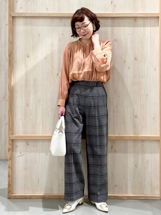 オレンジ系のシャツ/ブラウス、グレー系のその他パンツ、ホワイト系のトートバッグを着用したレディースの冬コーディネートの4枚目の写真