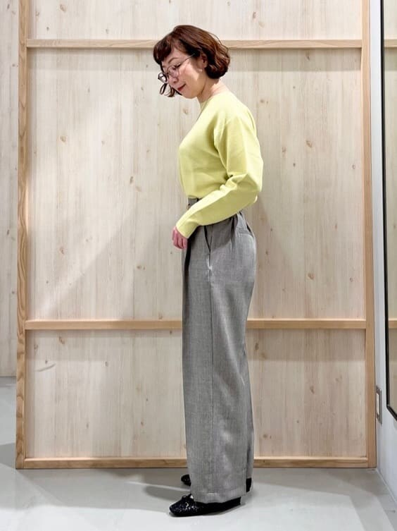 イエロー系のニット/セーター、グレー系のその他パンツ、グレー系のトートバッグを着用したレディースの冬コーディネートの2枚目の写真