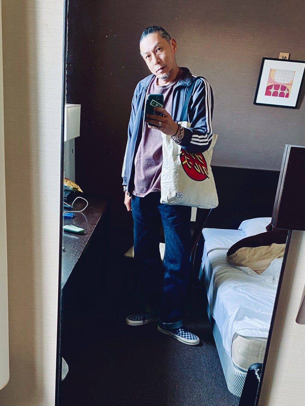 ブルー系のデニムパンツ、イエロー系のスニーカー、オレンジ系のその他アウターを着用したメンズの秋コーディネートの2枚目の写真