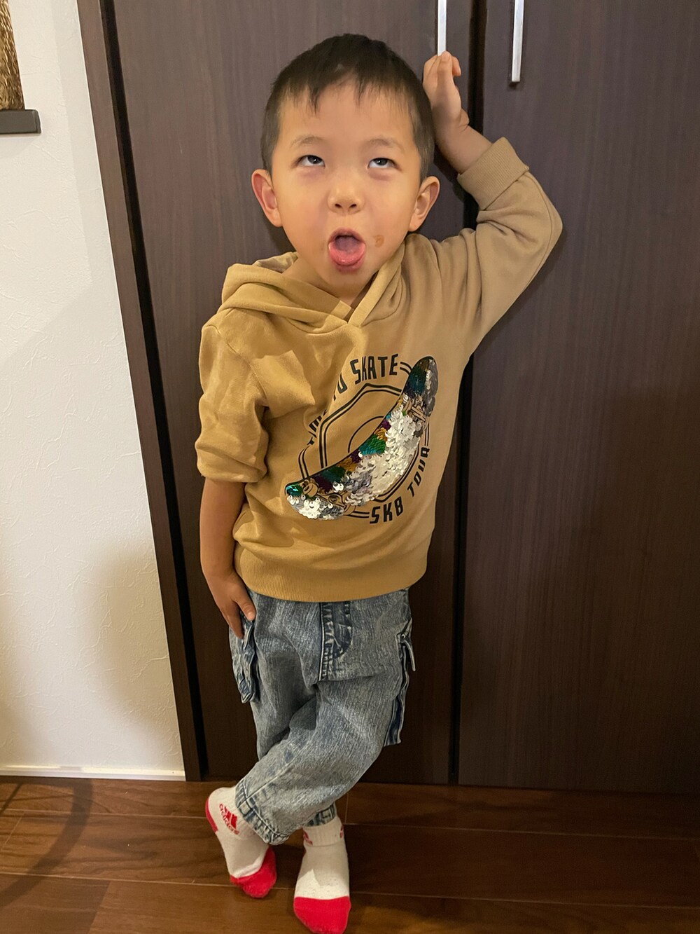 ブルー系のデニムパンツ、ベージュ系のパーカーを着用したキッズの秋コーディネートの2枚目の写真
