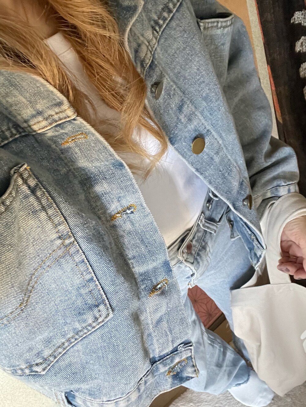 ベージュ系のトートバッグ、ブルー系のデニムパンツ、ブルー系のデニムジャケットを着用したレディースの春コーディネートの4枚目の写真