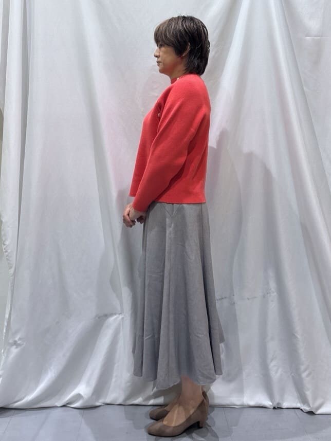 ピンク系のニット/セーター、グレー系のスカート、ベージュ系のパンプスを着用したレディースの冬コーディネートの2枚目の写真