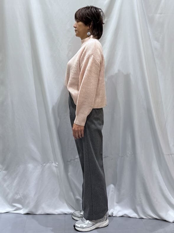 ピンク系のニット/セーター、グレー系のその他パンツ、シルバー系のスニーカーを着用したレディースの冬コーディネートの2枚目の写真
