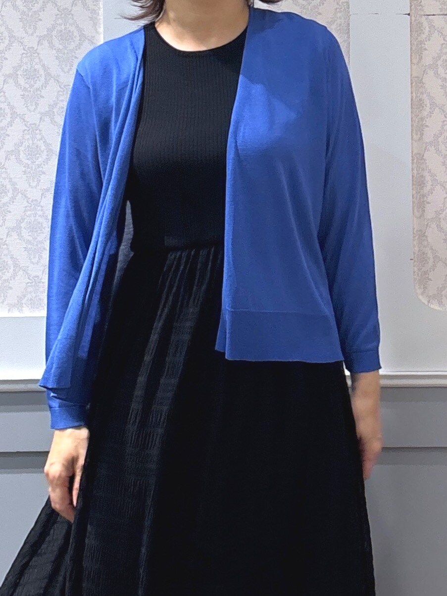ブラック系のその他シューズ、レッド系のポロシャツ、ブルー系のカーディガン/ボレロを着用したレディースの春コーディネートの4枚目の写真