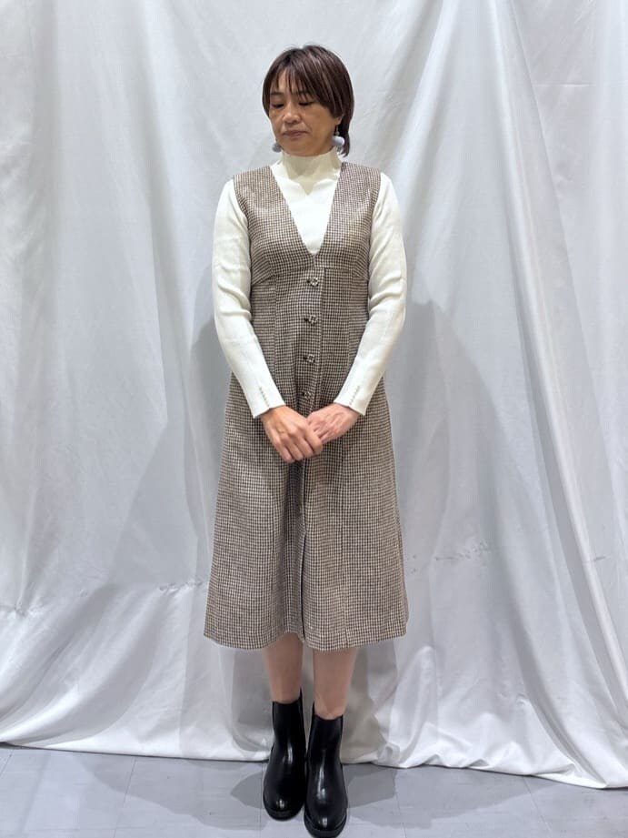 ブラック系のカーディガン/ボレロ、ホワイト系のニット/セーター、ブラウン系のワンピースを着用したレディースの冬コーディネートの5枚目の写真
